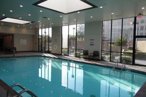 a large swimming pool in a building with windows at Wyndham Fort Smith City Center in Fort Smith
