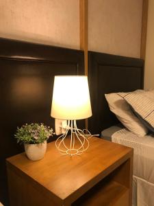 una lámpara en una mesa de madera junto a una cama en Apartamento Baviera, en Canela