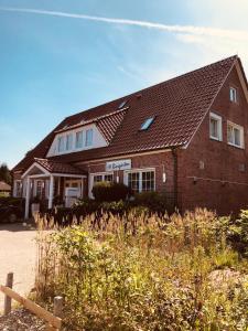 a brick house with a fence in front of it at Schlafstübchen in Leer