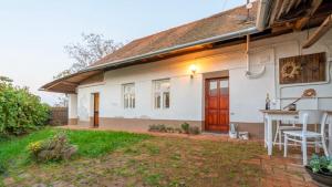 una casa bianca con tavolo e sedie in cortile di Čejkovický domek a Čejkovice