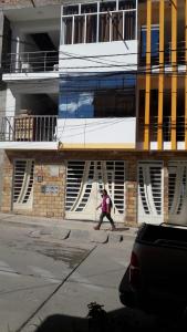 una persona caminando delante de un edificio en Alojamiento Huaraz, en Huaraz