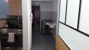 瓦拉斯Alojamiento Huaraz的一个小厨房，里面有水槽和炉灶。 更多39张照片