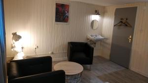a waiting room with a chair and a table and a sink at La Malle - la suite in Schiltigheim +23 photos