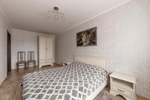 a bedroom with a bed and a table and chairs at Apartment in the city center in Baranavichy