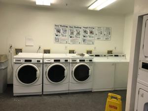 a laundry room with three washing machines in it at InTown Suites Extended Stay Orlando FL - Universal in Orlando