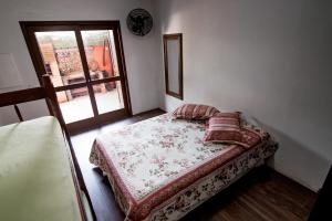 a small bedroom with a bed and a window at Morada Canto Norte - Apartamentos Beira Mar in Garopaba