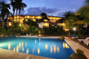 a resort with a swimming pool at night at Villa Caribe in Lívingston