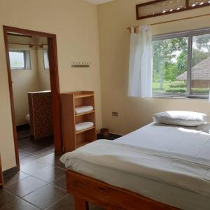 Bushbaby Lodge في Mukono: غرفة نوم بسرير ونافذة
