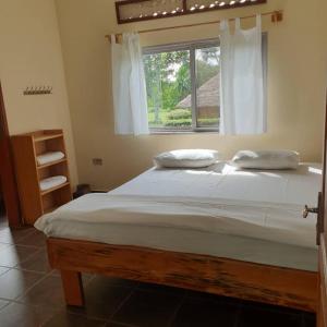 a bedroom with a large bed with a window at Bushbaby Lodge in Mukono