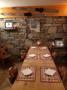 a long table in a room with a stone wall at Hôtel Arolla in Bourg-Saint-Maurice