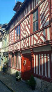 - un bâtiment rouge et blanc avec une porte rouge dans l'établissement -La Batisse -Parking privé -Coeur historique - La Clef de Honfleur, à Honfleur