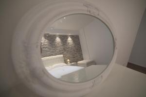 un riflesso a specchio di un letto in una stanza di Malenki a Roma
