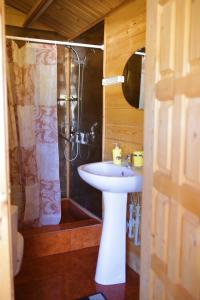 a bathroom with a white sink and a shower at Guest House Apsar Village in Novy Afon