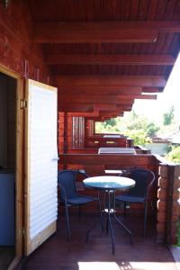 un patio con mesa y sillas en un porche en Guest House Apsar Village, en Novi Afon