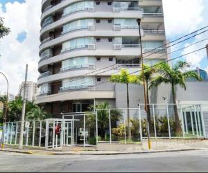 un grand bâtiment blanc avec des palmiers devant lui dans l'établissement Be Paulista apartamento 77, à São Paulo