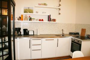 a kitchen with white cabinets and a sink at Lieblingsnest Detmold in Detmold