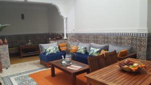 Riad Medina في مراكش: غرفة معيشة مع أريكة زرقاء وطاولة