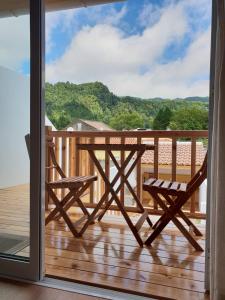 a balcony with a table and chairs on a deck at Domus Nostra in Furnas