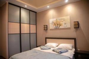 a bedroom with a bed with two pillows on it at Квартира Люкс in Vinnytsya
