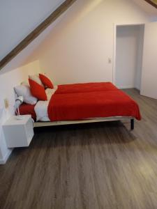 オットンにあるLa Vieille Tourのベッドルーム1室(大型ベッド1台、赤と白の枕付)
