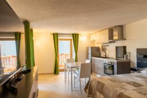 a room with a kitchen and a table with chairs at Rayon de Miel in Aosta