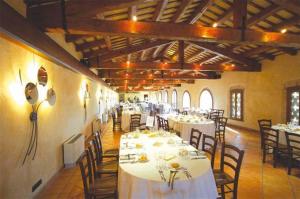 a dining room with white tables and chairs in a building at Hotel Fossa Mala in Fiume Veneto