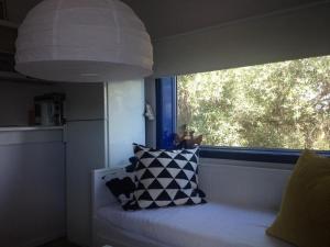 a room with a window with a couch and a pillow at Maria Corfu Loustri in Corfu Town