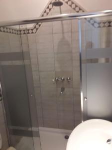 a shower with a glass door in a bathroom at Silencioso departamento antiguo in Buenos Aires