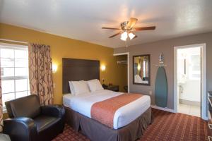 a hotel room with a bed and a chair at Capitol Hill Motel in Portland