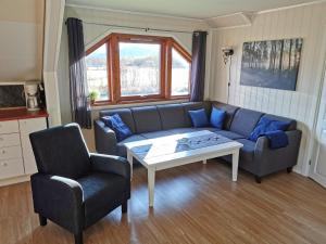 a living room with a couch and a table and a chair at Reipå Camping in Reipå
