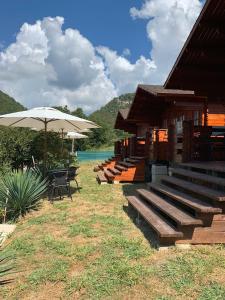 a building with benches and a table and an umbrella at Guest House Apsar Village in Novy Afon