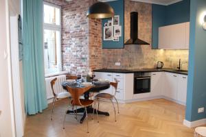 kuchnia ze stołem i krzesłami oraz ceglaną ścianą w obiekcie Dominican Square by Hashtag Apartments w Krakowie +37 zdjęć