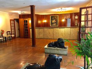 a lobby with a statue in the middle of a room at Hotel Montanhes in Miguel Pereira