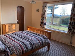 sypialnia z łóżkiem z komodą i oknem w obiekcie Travellers Rest w mieście Launceston