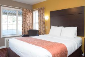 Capitol Hill Motel في بورتلاند: غرفة فندقية بسرير كبير ونافذة