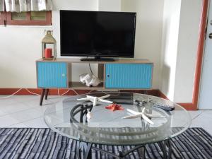 a living room with a glass coffee table and a tv at Amazing Beach View Apartments in Castries