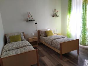 twee bedden in een slaapkamer met groene gordijnen bij Casa Violina in San Pietro Avellana +30 foto's