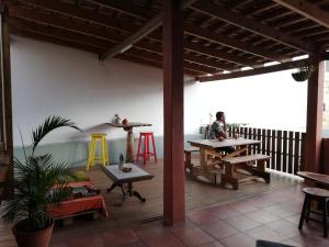 a person sitting at a table on a patio at The Base Backpackers in Maputo