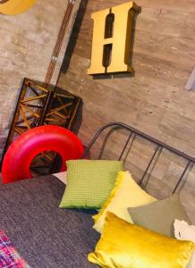- une vue de tête sur un lit avec des oreillers jaunes et une chaise rouge dans l'établissement Les chambres atypiques de Nico Bush - Parking sécurisé vélos, à Tournai