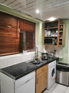 a kitchen with a sink and a washing machine at Memory Homes MM H in Manchester
