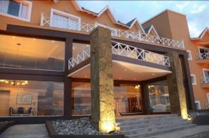 a large house with a balcony on top of it at Hotel Las Dunas in El Calafate