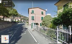 a street with a pink house and a fence at L'angolo di Chiavari in Chiavari