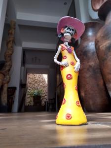 a figurine of a woman in a yellow dress at Casa 5 Bed & Breakfast in Palenque