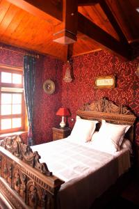a bedroom with a bed with red wallpaper at La Minauderie in &Eacute;cully