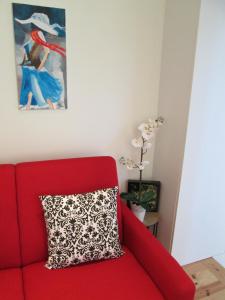 a red couch with a pillow next to a painting at 4PortoApartments#2 in Porto