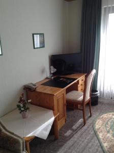 a desk in a room with a table and a chair at Hotel Zum Stresemann in Göttingen