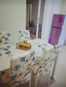 ein Esstisch mit zwei Stühlen mit Blumen darauf in der Unterkunft Full House Emerald Villa i6 2 BR Near JTP 3 in Batu