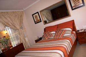 um quarto com uma cama e uma janela em Ekhaya Lodge em Pietermaritzburg
