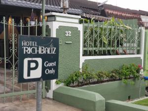 a street sign in front of a building with plants at Richbaliz Homestay @ Selayang Jaya in Batu Caves
