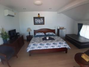 a bedroom with a bed and a chair at Nong Nuey Rooms in Ko Samed